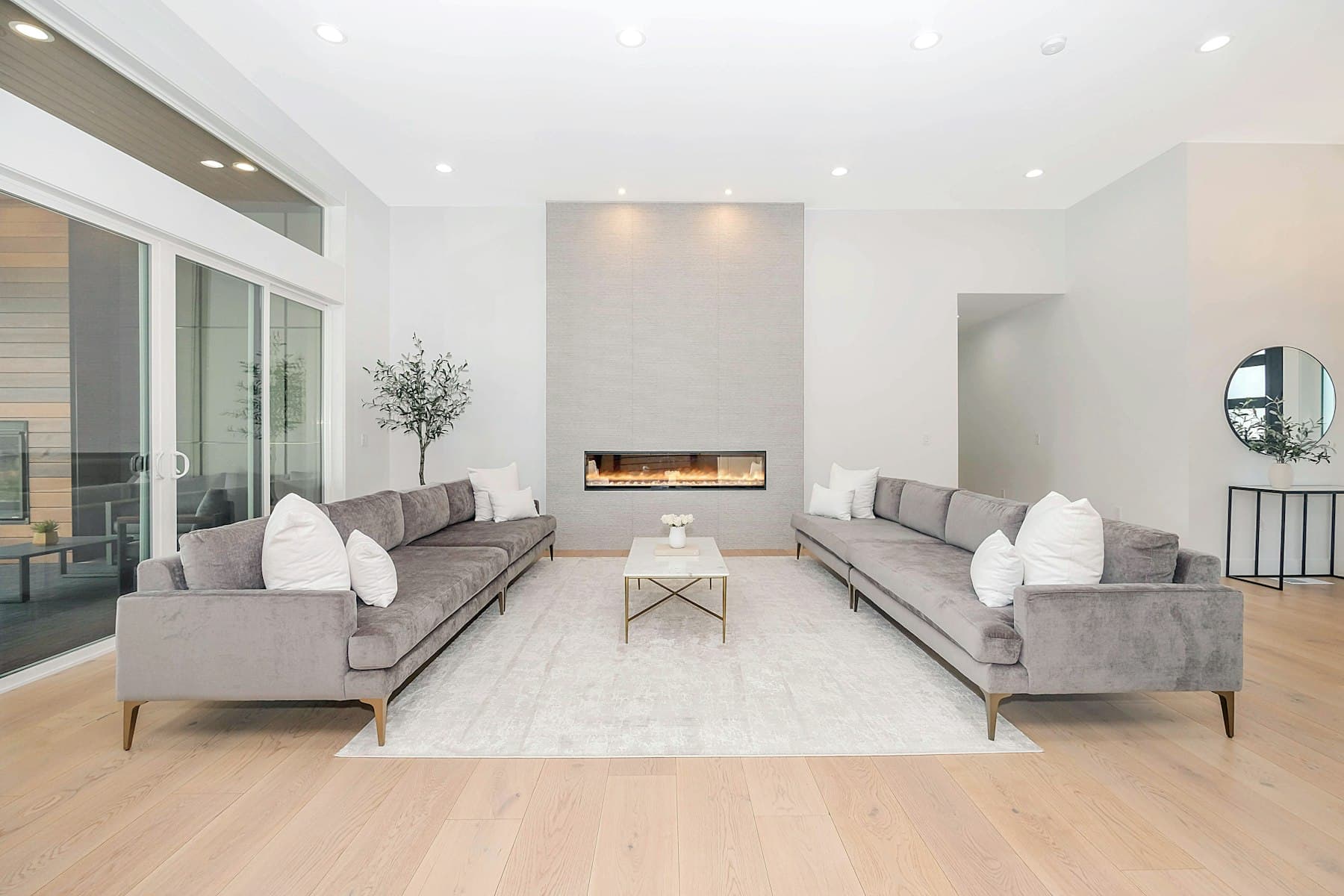 A bright living room with two facing sofas and full-height windows